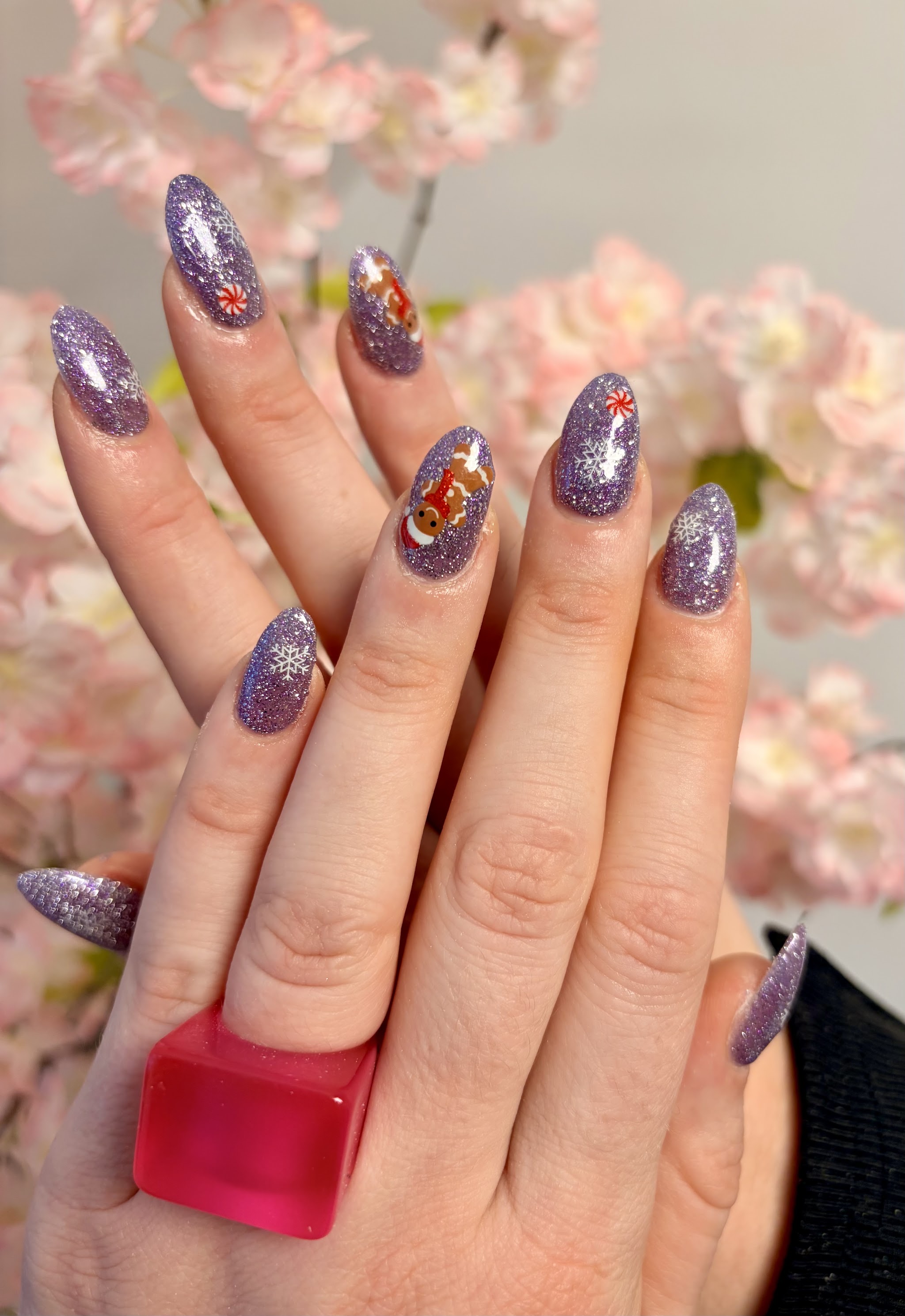 Paarse glitter amandelnagels voor een kersenbloesem achtergrond