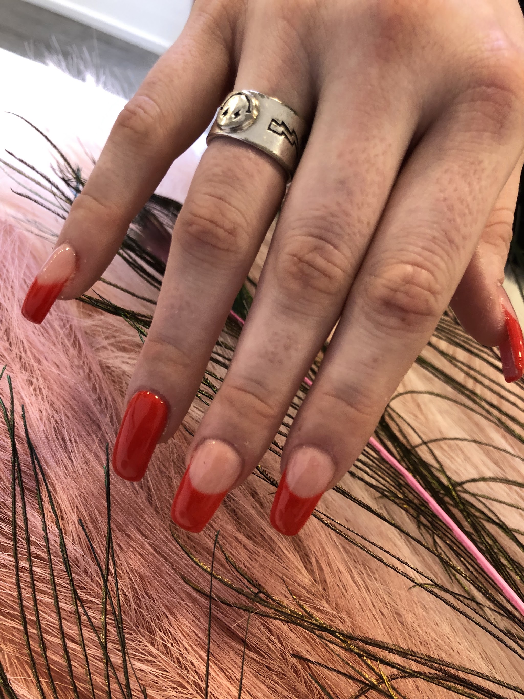 Rode French tip nagels boven pauwenveren